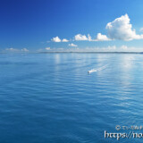 鏡のような青い海を走るボート