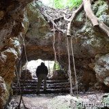 背をかがめて通る洞窟の出口-牧山陣地壕