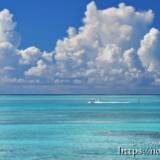 池間ブルーの海を走るボートと入道雲