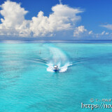 海の道を疾走するボートと入道雲