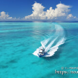 池間ブルーの海を疾走するボートと入道雲