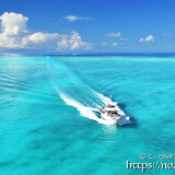 池間ブルーの海を疾走するボートと入道雲