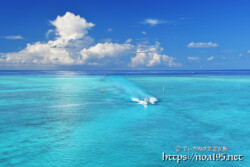 池間ブルーの海を走るボートと入道雲