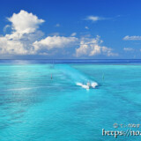 池間ブルーの海を走るボートと入道雲