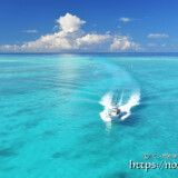 池間ブルーの海を走るボートと入道雲
