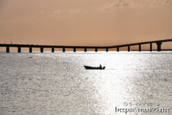 伊良部大橋と光の中の漁船-サンセットビーチ