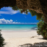 洞窟を覆う植物とビーチの入道雲-曲元の浜