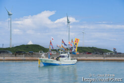 大漁旗を掲げて青い海を走る漁船-狩俣海神祭