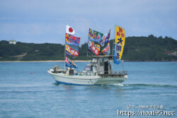 大漁旗を掲げて青い海を走る漁船-狩俣海神祭