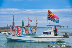 大漁旗を掲げて青い海を走る漁船-狩俣海神祭