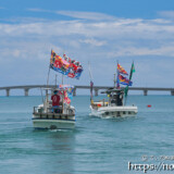 大漁旗を掲げて青い海を走る漁船-狩俣海神祭