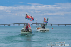 大漁旗を掲げて青い海を走る漁船-狩俣海神祭