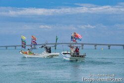 大漁旗を掲げて青い海を走る漁船-狩俣海神祭