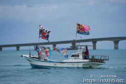 大漁旗を掲げて青い海を走る漁船-狩俣海神祭