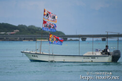 大漁旗を掲げて青い海を走る漁船-狩俣海神祭