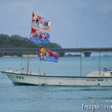 大漁旗を掲げて青い海を走る漁船-狩俣海神祭