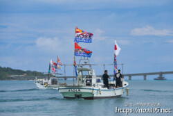 大漁旗を掲げて青い海を走る漁船-狩俣海神祭