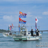 大漁旗を掲げて青い海を走る漁船-狩俣海神祭