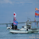 大漁旗を掲げて青い海を走る漁船-狩俣海神祭