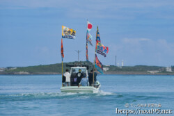 大漁旗を掲げて青い海を走る漁船-狩俣海神祭