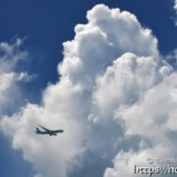 そびえ立つ入道雲と飛行機