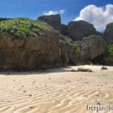 崖下に積み重なる巨岩と砂浜の波紋-東平安名ビーチ