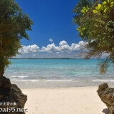 岩の間から見るビーチと青い海-マサカダツ